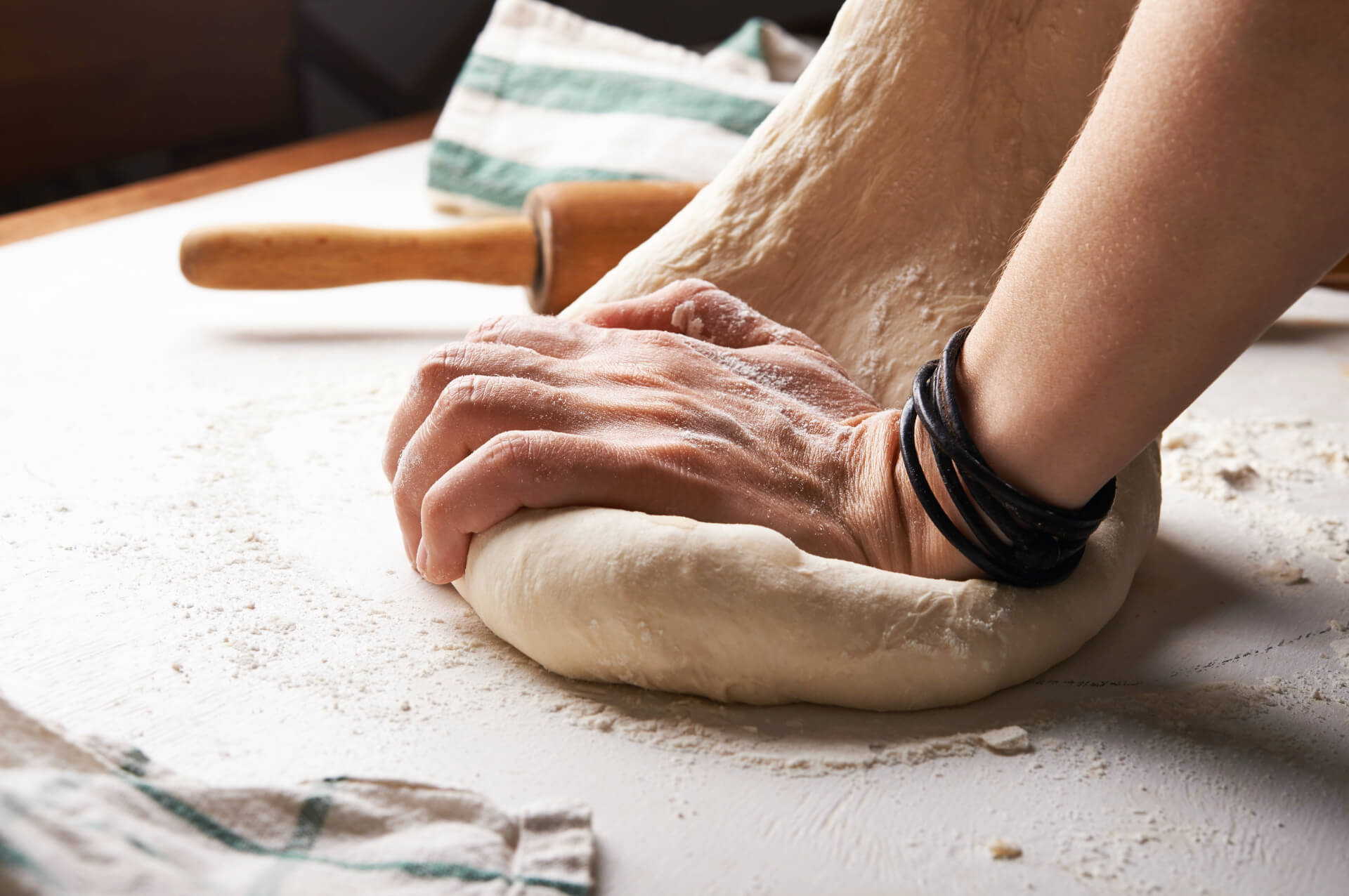 Hands kneading fresh dough at Rana Bakery